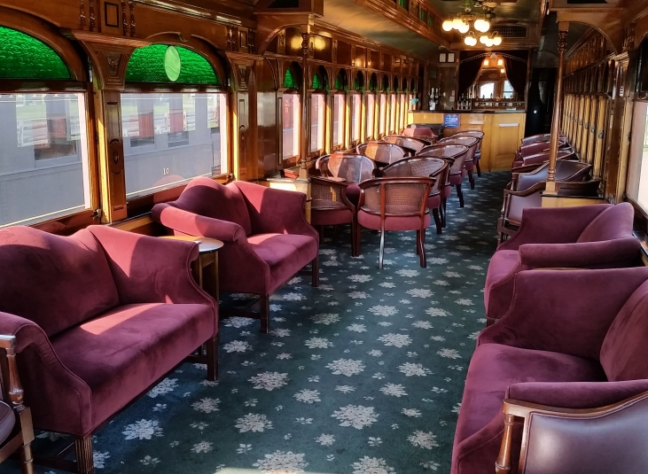 The Parlor train car filled with red velvet couches and armchairs.