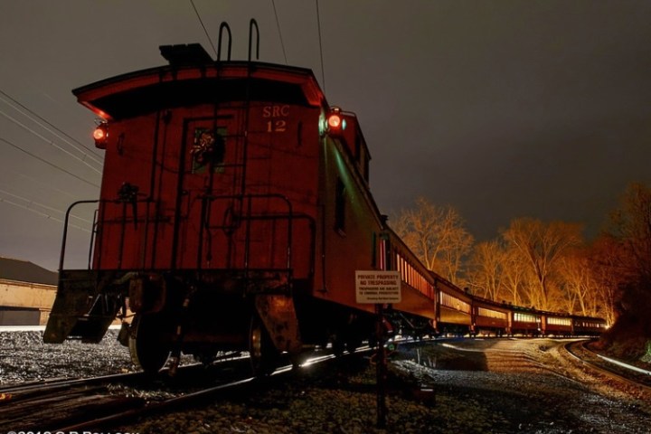 The outside view of the caboose on the train tracks at night.