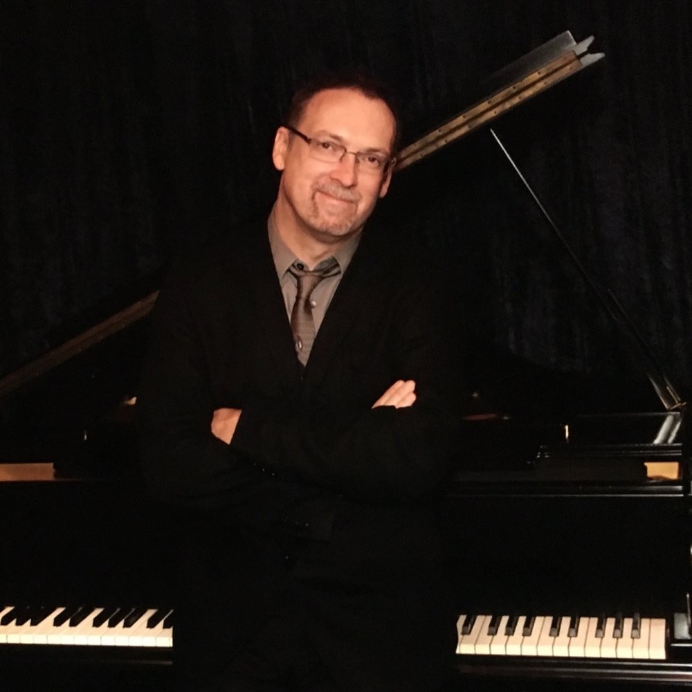 a man standing in front of a piano