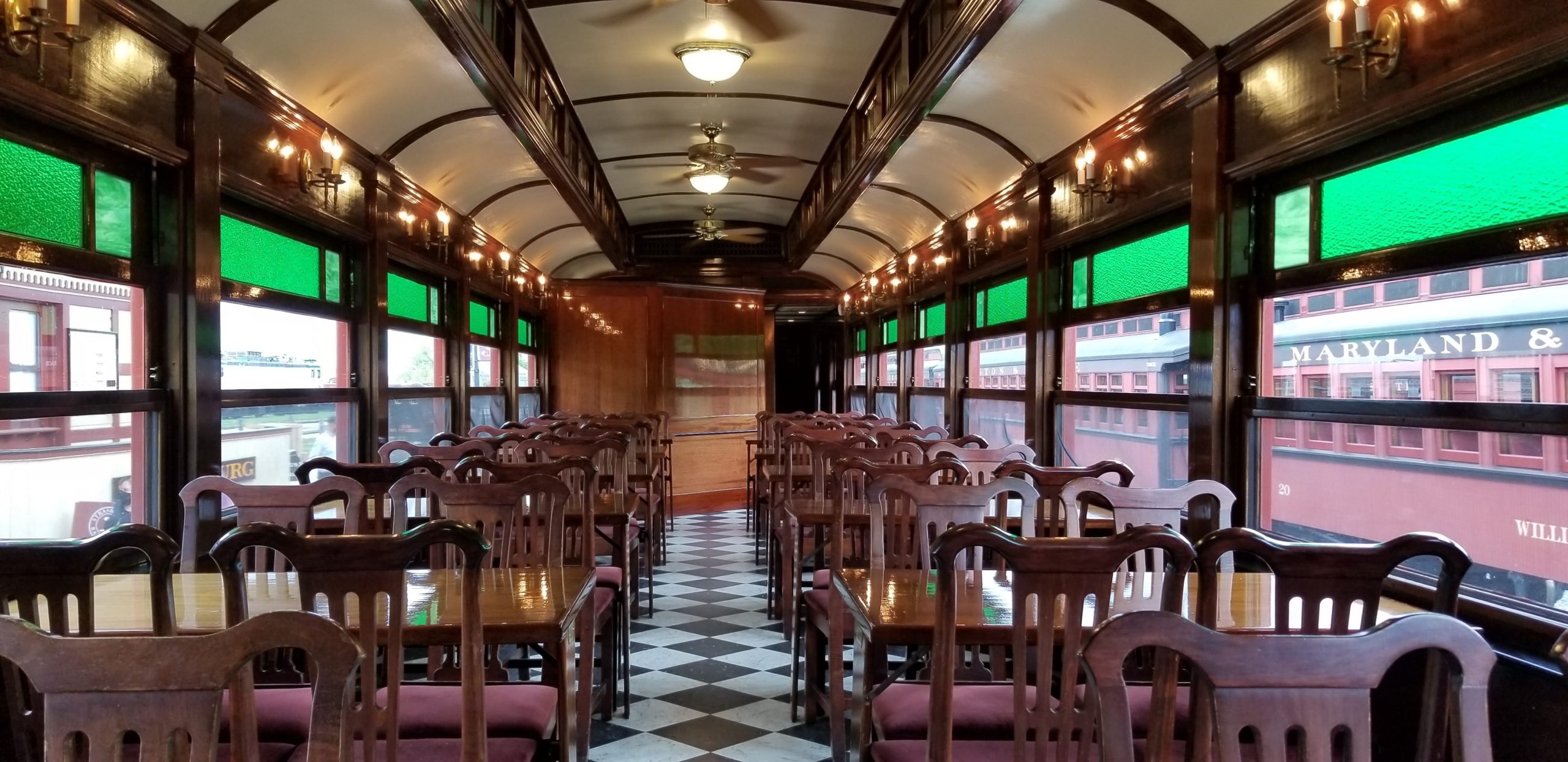 Empty tables and chairs lined up inside a historic dining car at the Strasburg Rail Road.