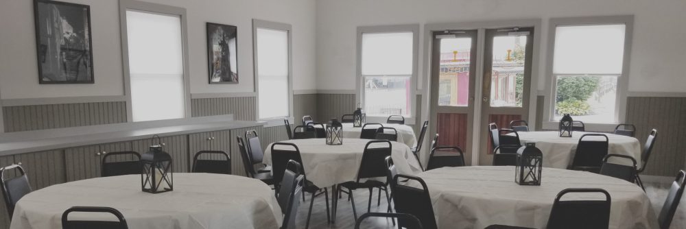 Several set round tables in a room for an event.