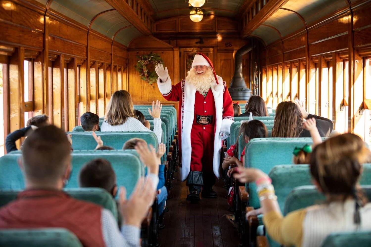 santa waving to a train car full of families