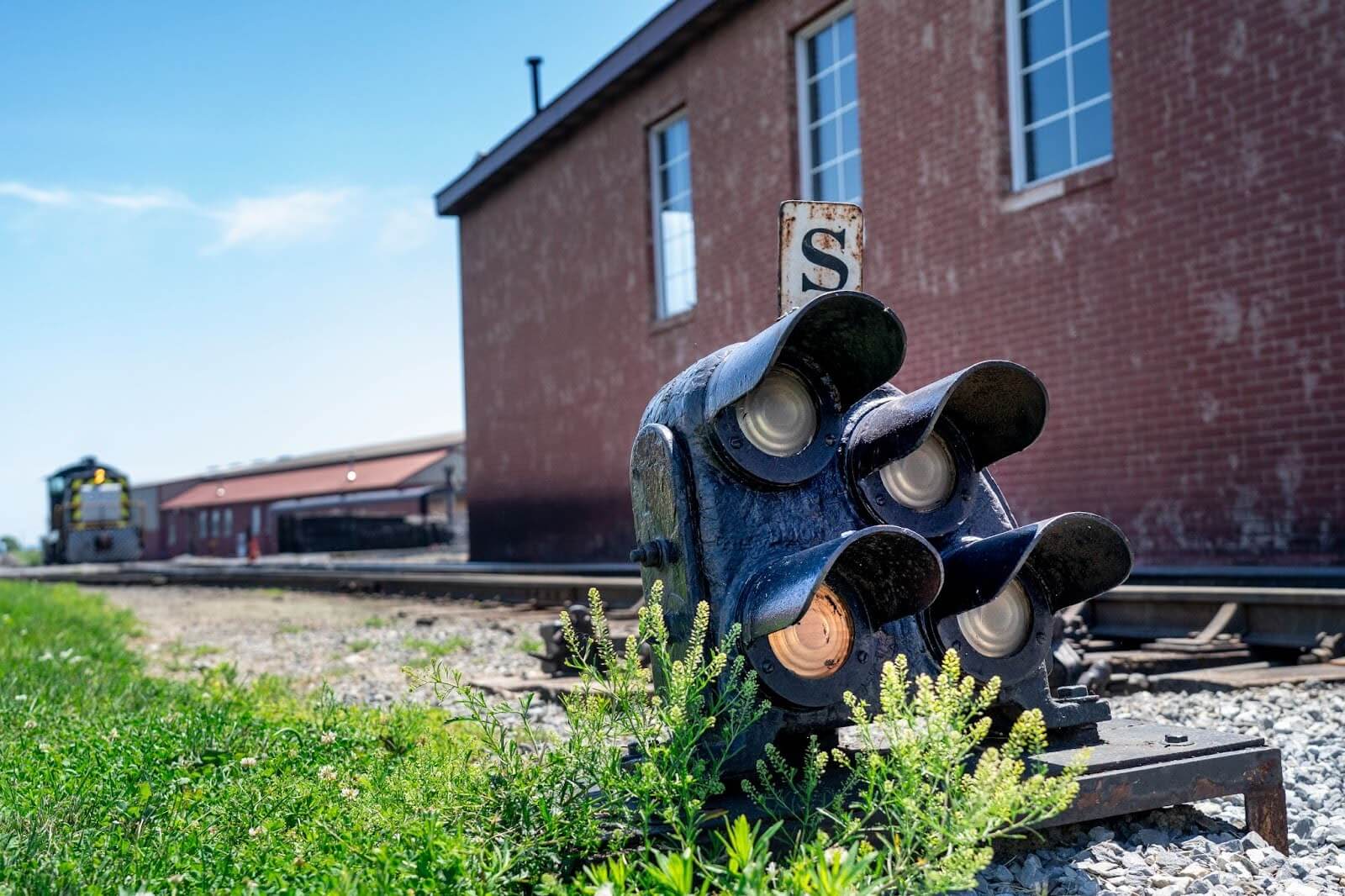 A railroad signal sitting on the ground to direct train traffic.